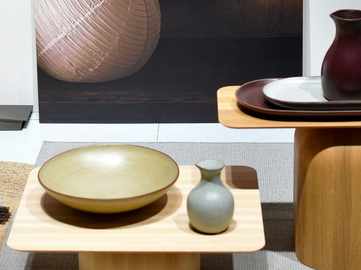 Schalen en kannen op twee houten bijzettafels op een beursstand